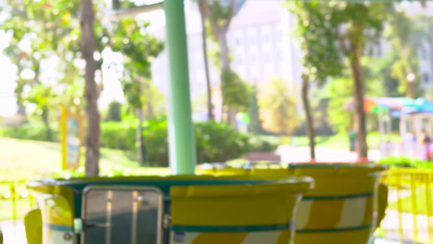 Woman and her kids enjoy riding an attraction of a tea cups spinning in a circle.