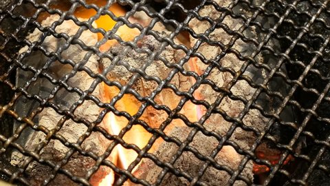 4K burning coal. close up of red hot coals glowed in the stove under BBQ Grill and glowing coals.