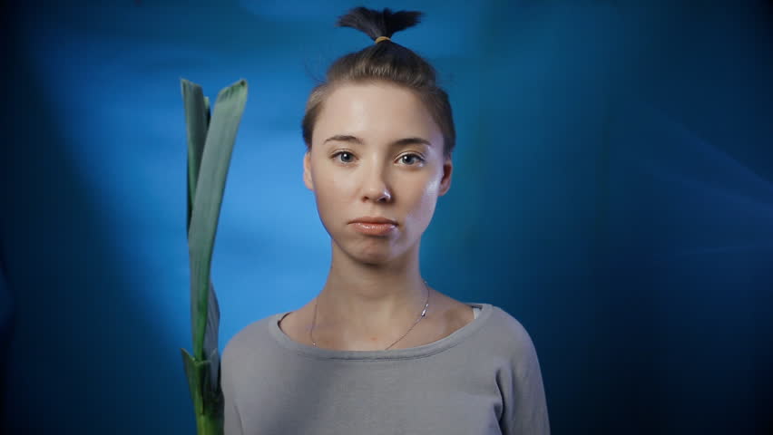Sad girl with celery. Close up. Joke