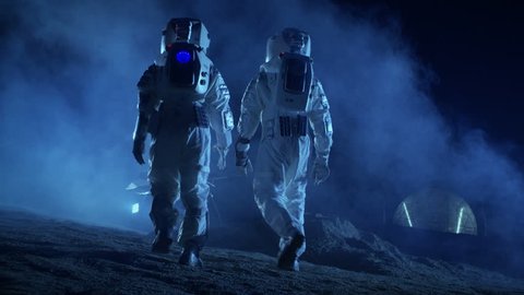Following Shot of Two Astronauts in Space Suits on Alien Planet Walking Toward Rover and Geodesic Dome. High-Tech Space Exploration Concept. Shot on RED EPIC-W 8K Helium Cinema Camera.
