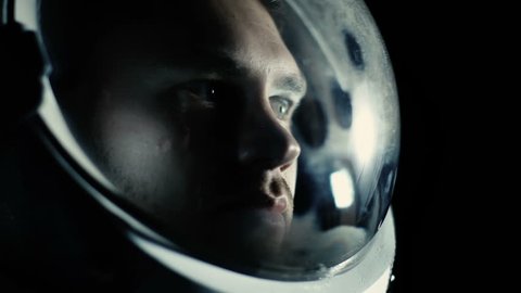 Portrait Shot of the Courageuos Astronaut Wearing Helmet in Space, Looking around in Wonder. Space Travel, Exploration and Solar System Colonization Concept. Shot on RED EPIC-W 8K Helium Cinema Camera