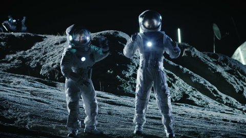 Male and Female Astronauts Wearing Space Suits Dance on the Surface of the Alien Planet. Humanity Colonizing Space Celebration Theme. Shot on RED EPIC-W 8K Helium Cinema Camera.