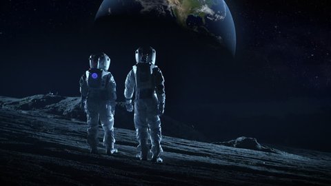 Crew of Two Astronauts in Space Suits Standing on the Moon Looking at the Beautiful Earth. High Tech Concept of Moon Colonization and Space Travel. Shot on RED EPIC-W 8K Helium Cinema Camera.