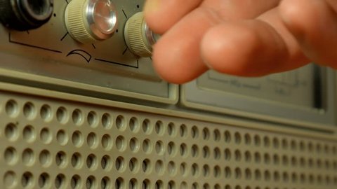 Men hand tuning vintage radio. Men is hitting the sound old Radio dial