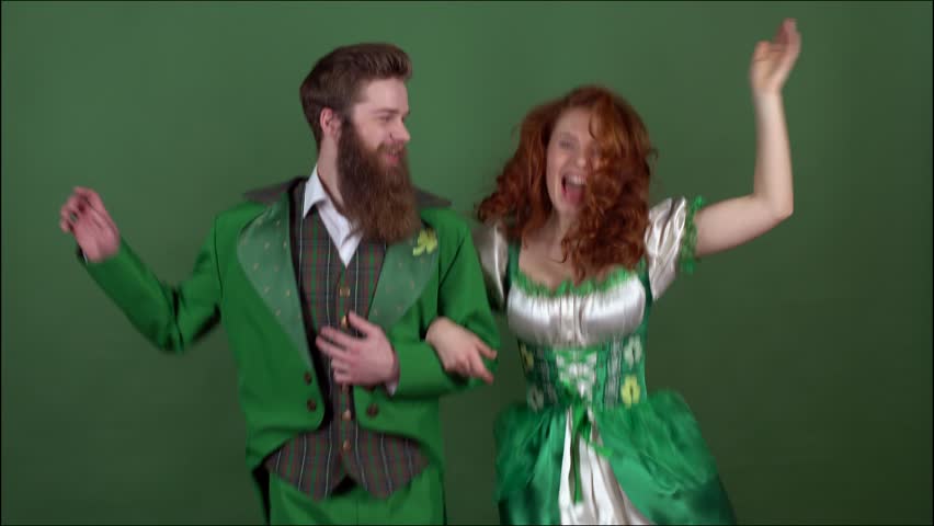 Young couple in costumes celebrating saint patrick's day isolated on green wall dancing together Royalty-Free Stock Footage #1007771086