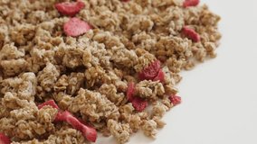 Pile of dehydrated crunchy cereals slow tilt 4K 2160p 30fps UltraHD footage - Tilting over muesli with strawberry flavour close-up 3840X2160 UHD video