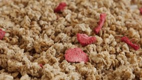 Dehydrated crunchy cereals slow tilt 4K 2160p 30fps UltraHD footage - Tilting over  muesli with strawberry flavour close-up 3840X2160 UHD video