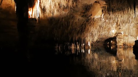 MAJORCA, SPAIN Tourists float on a boat on the underground lake in the famous stalactite caves of Dragon (Cuevas del Drach)