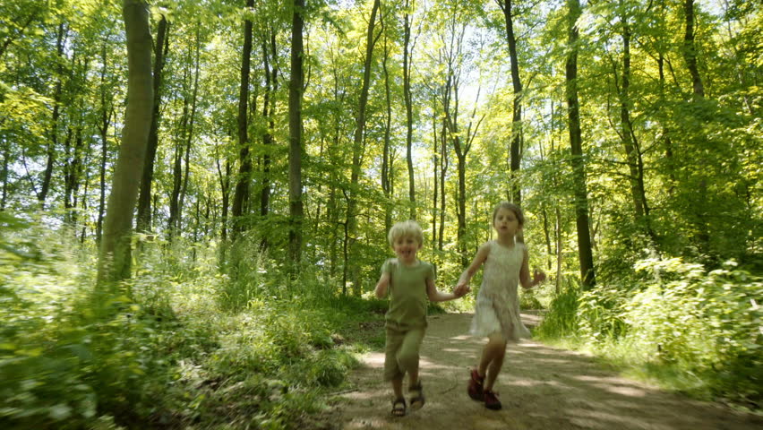 Brother and sister running through lush forest, Denmark Royalty-Free Stock Footage #1007786056
