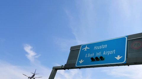 airplane flying over houston airport signboard