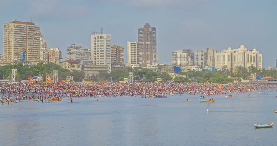 Day to night time lapse of a crowded beach where huge Ganesha idols are lined up for Ganapati or Ganesh Visarjan (immersion) during Ganesha Chaturthy on Girgaon Chowpatty, Mumbai, India Royalty-Free Stock Footage #1007796079