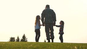 Back view soldier in uniform walk with daughters. Military man in camoubackgrounde walking holding hands of his little daughters. - Powered by Shutterstock - Get 15% off with code: PIKWIZARD15