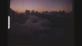 CARIBBEAN, MAY 1971. Airplane Flying Over The Clouds At Sunrise. POV View Of The Wing Shot Out Of A Cabin Window