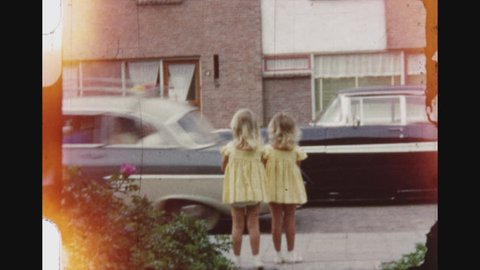 NOORDWIJK, NETHERLANDS, SUMMER 1956. Six Shot Sequence Of Little Blond Twin Girls Dressed In Yellow Joking With The Camera And Running On The Sidewalk.