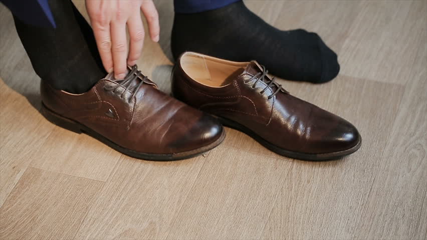 a man ties up his shoelaces