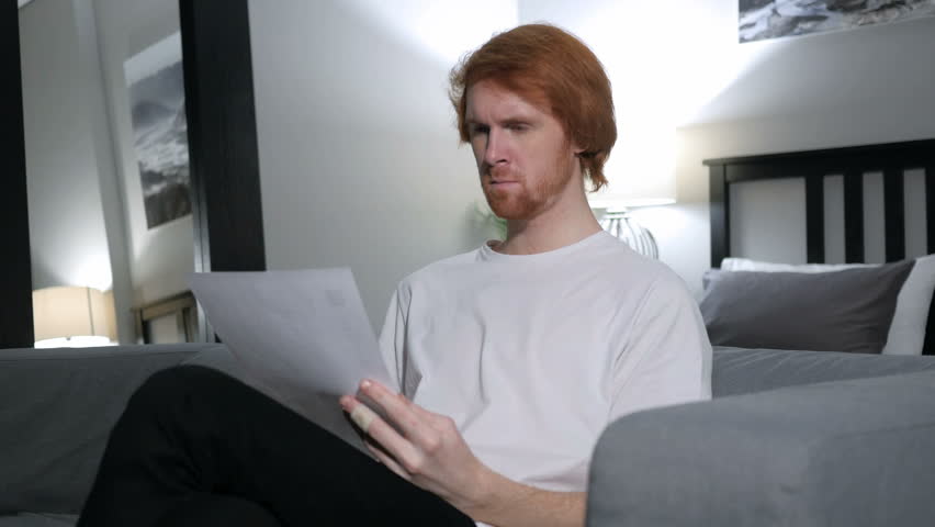 Penisve Redhead Man Reading Letter, Sitting on Sofa