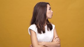 Young shocked surprised woman standing isolated over yellow background while looking camera