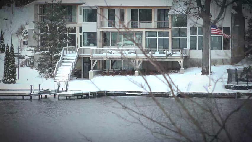 4k Shoreline cottage winter landscape by a snow covered lake