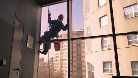 climber washes windows in a skyscraper