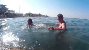 Couple plays and splashes in the sea, Entertainment on the sea, Video clip