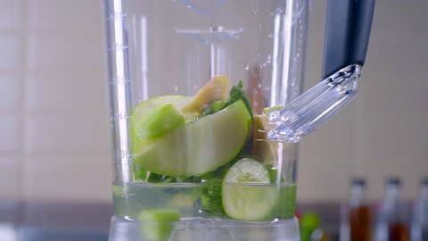A blender jar with green healthy smoothie.