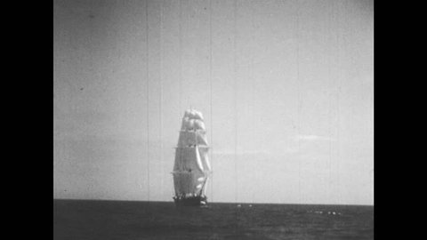 1950s: 19th century sailing ship at sea. 13-star American flag (Betsy Ross Flag) blowing in the wind.