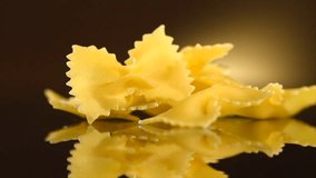 Pasta Farfalle rotated on dark background. Italian mediterranean food, diet, dieting. Cooking Italian pasta bow close-up. Slow motion 4K UHD video