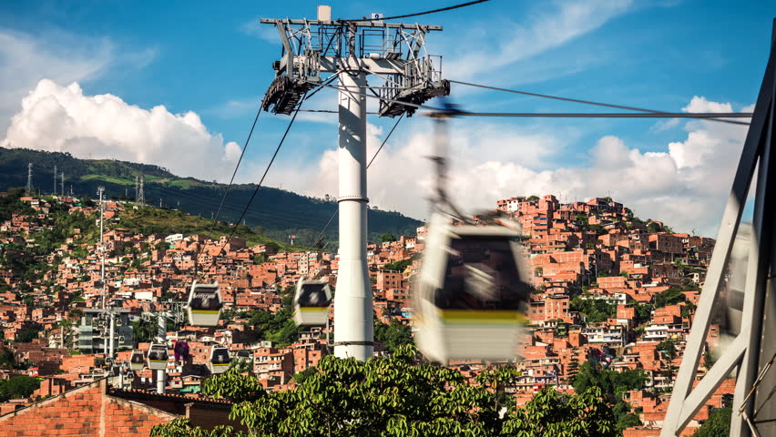 Medellin, Colombia, time lapse view of the iconic Metrocable (cable car) system over Comuna 13 slums during daytime.