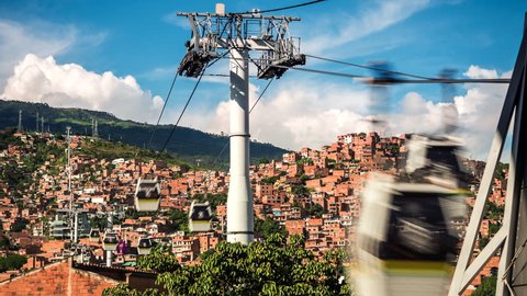 Medellin, Colombia, time lapse view of the iconic Metrocable (cable car) system over Comuna 13 slums during daytime.