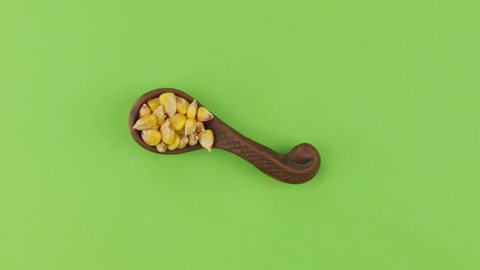 Rotation and approach of the spoon with corn grains, green screen.
