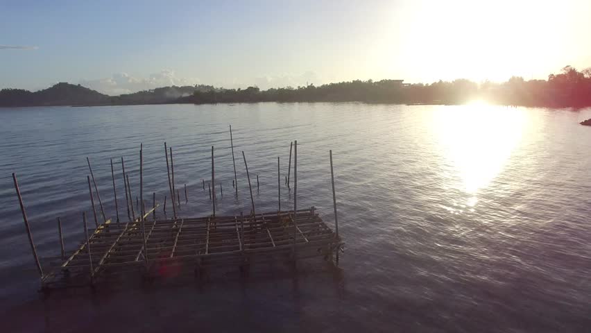 Los Banos, Laguna, Philippines - February 23, 2018: Sun rises over bamboo structure built in the middle of the lake. silhouettes, drone aerial | Shutterstock HD Video #1007864704