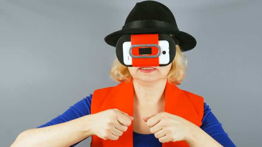 beautiful woman in hat and  virtual reality glasses imitates a play on musical instruments