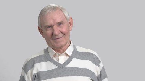 Cheerful grandfather on grey background. Happy male pensioner. Elderly smiling man in casual sweater.