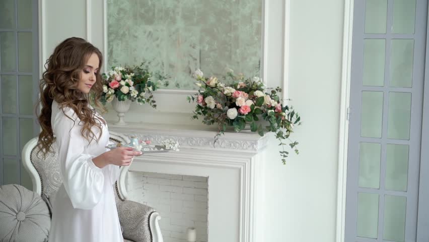 Young beautiful woman posing in white lingerie with tray