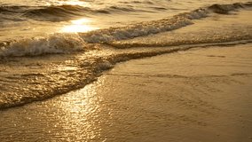 4K amazing sunset over the tropical beach. ocean beach waves on beach at sunset time , sunlight reflect on water surface. beautiful evening nature sea background.