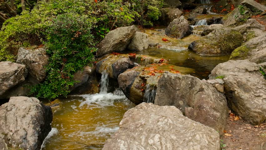 Waterfall on rocks cascade in artificial japanesse garden, zoom in