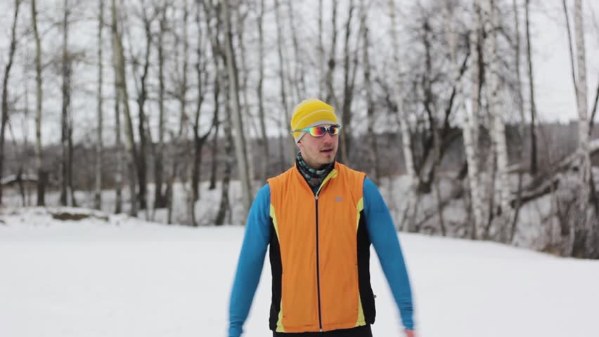 sports guy doing exercises in the snow-covered forest