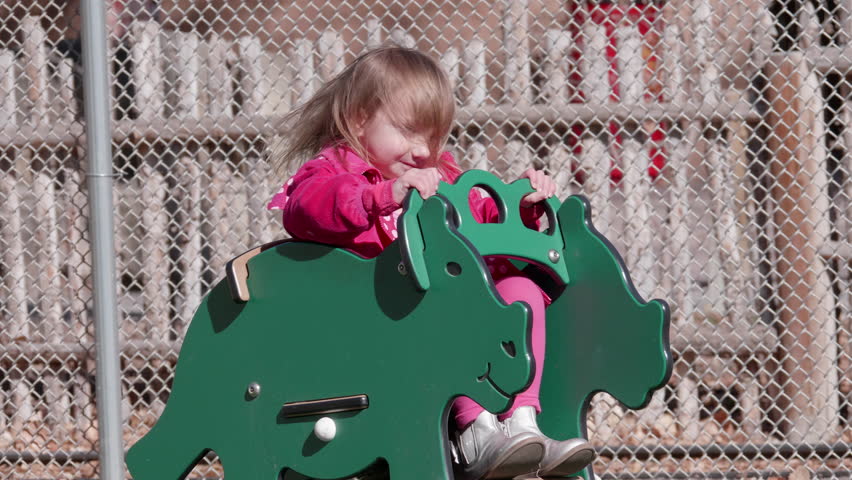 This is a shot of a little girl on a spring rocker in a playground. Shot on a GH5