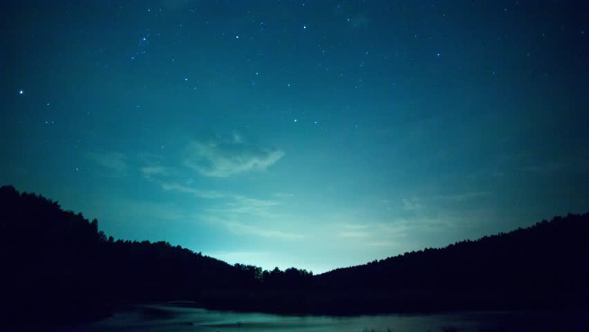 Stars over the lake at summer night on dark sky. Starfall. Amazing milky way galaxy with big amount of stars. Star trails, beautiful blue night, Star trails over the river and mountain