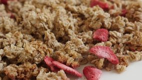 Strawberry flavor muesli on pile close-up 4K 2160p 30fps UltraHD panning footage - Dehydrated crunch cereals slow pan 3840X2160 UHD video