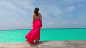 Woman Wearing a Red Dress Admiring the Blue Ocean with Turquoise Waters in Maldives 4k