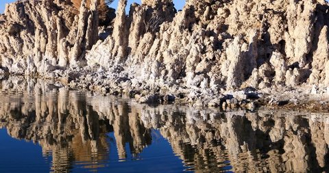 Mono lake tufas with reflection in calm water close-up on sunrise.