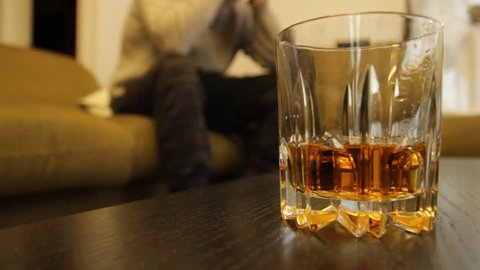 Man Struggles With Alcohol Abuse Glass liquor in focus caucasian