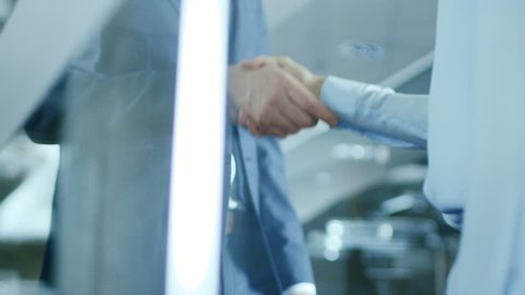 Close-up of the Businesswoman and Businessman Shaking Hands with Emphasis on the Handshake. Shot on RED EPIC-W 8K Helium Cinema Camera.