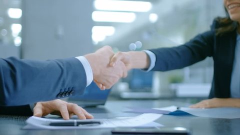 In the Office Close-up on Hands of Businesswoman and Businessman while Signing Contracts and Shaking Hands for Finishing Transaction. Stylish People in Modern Conference Room. Shot on RED EPIC-W 8K.
