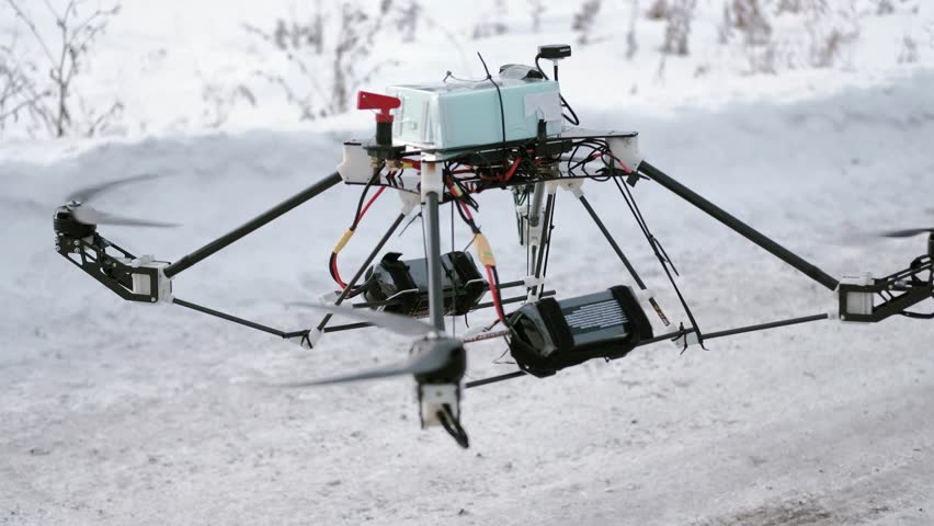 Aerial, drone landing on the electric transmission tower, on the power distribution cables for wire check