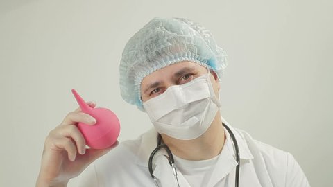 Doctor shows enema and smiles