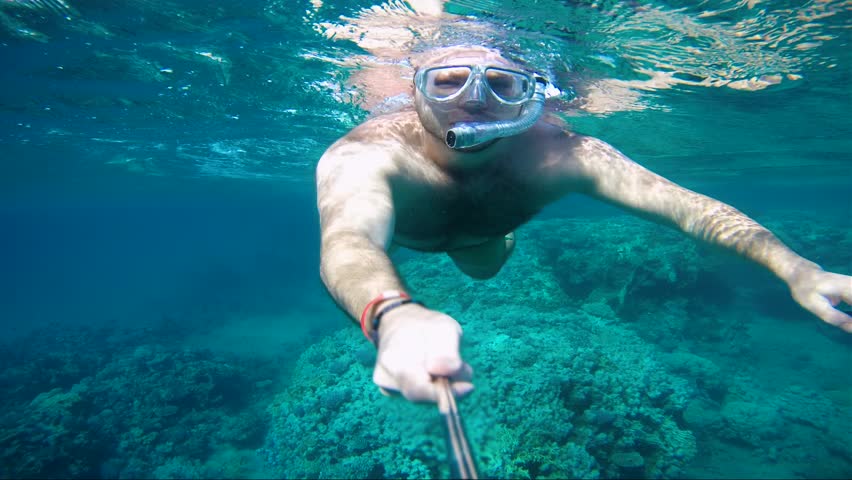 Man is snorkling and filming with an action camera | Shutterstock HD Video #1007945107