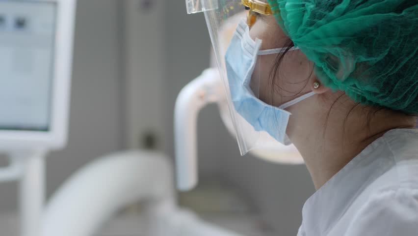 Woman in medical mask and rubber gloves holds hose and inserts it in patient mouth close-up | Shutterstock HD Video #1007956978