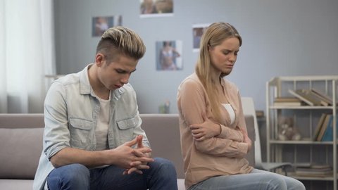 Upset girl looking hurt at guy waiting apology, difficulties in relationship